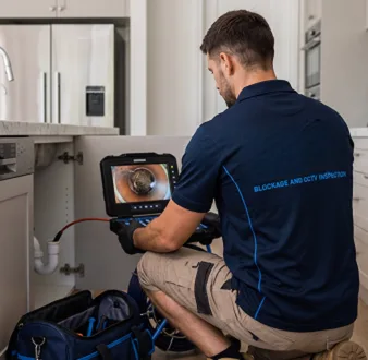 Plumber clearing a blocked toilet in a Cabarita bathroom